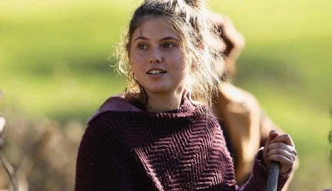 Aloisa Bargilli sul set di Cinque secondi, con un maglione bordeaux, un attrezzo in mano, al sole