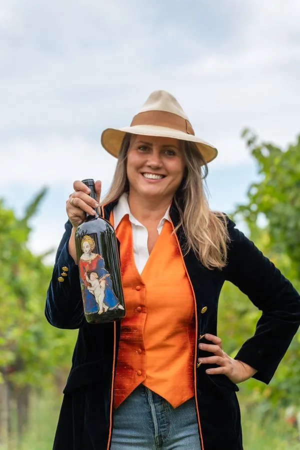 Augusta Bargilli in vigna, con il magnum dipinto in mano